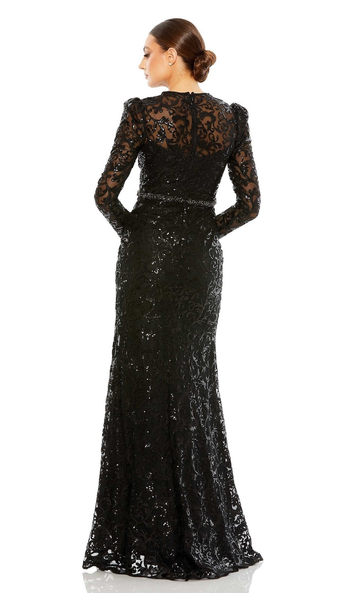 Woman wearing the Mac Duggal 68011 long beaded-lace formal dress with sheer long sleeves, standing with her back to the camera and her hair in a neat bun.